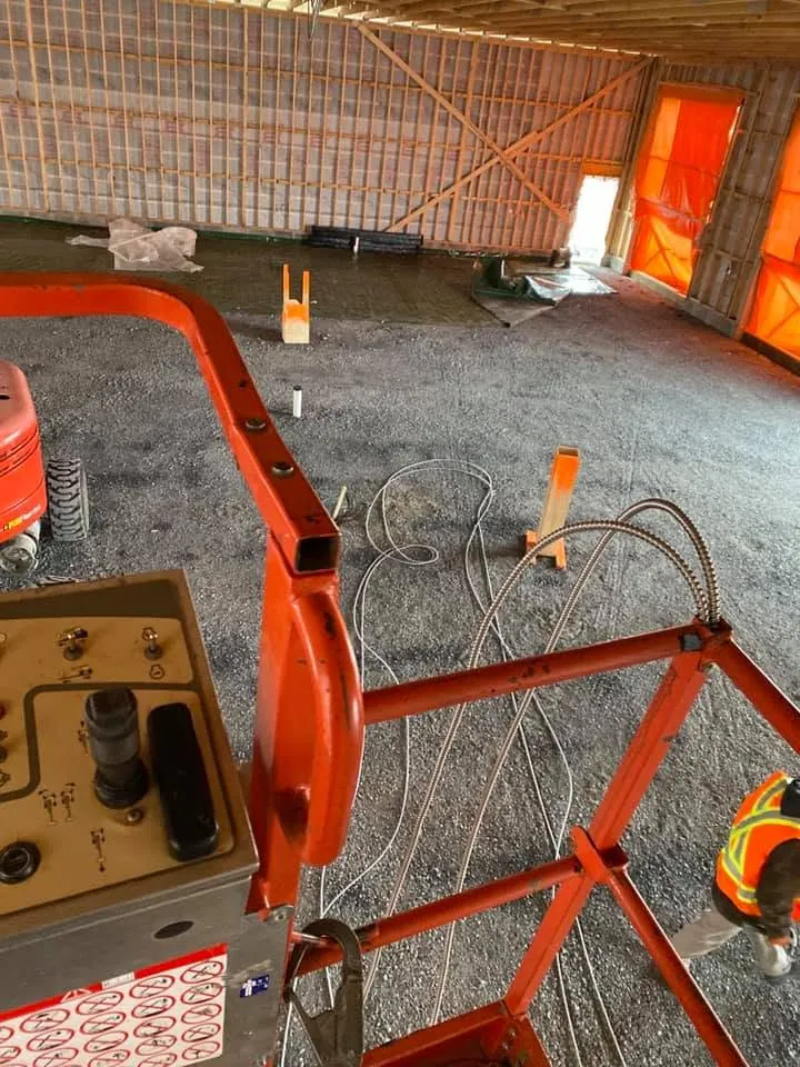 Electrical rough-in underway across the floor of a commercial construction site.