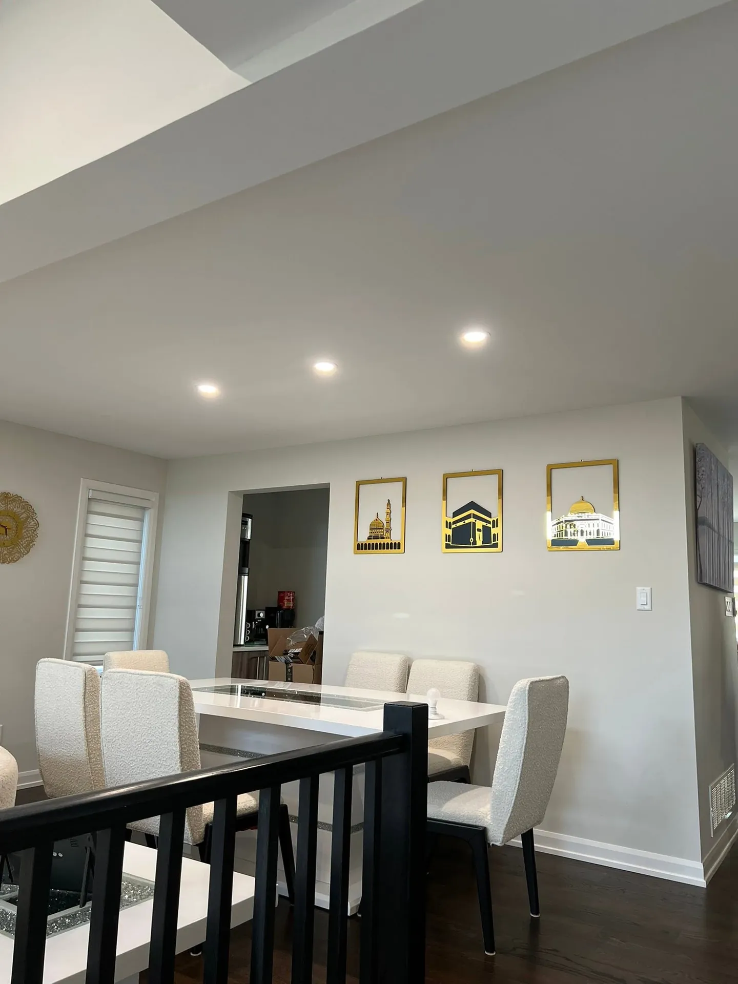Dining area evenly illuminated by recessed ceiling pot lights.
