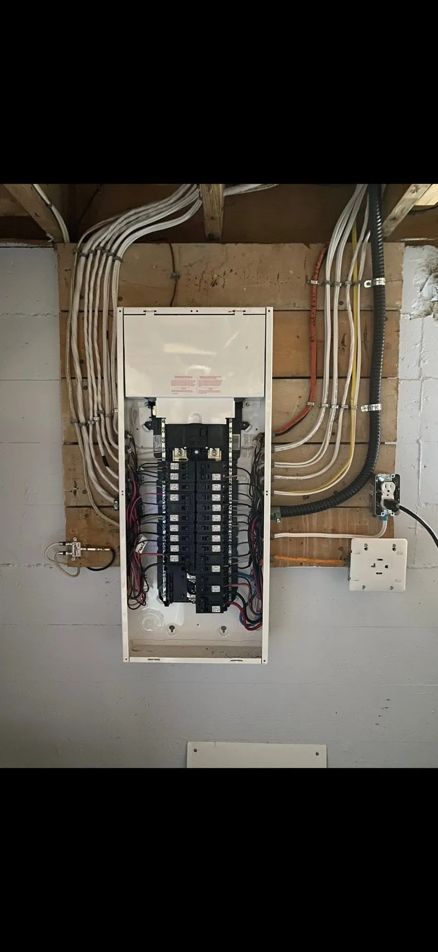 Completed electrical panel with organized feeder and branch wiring.