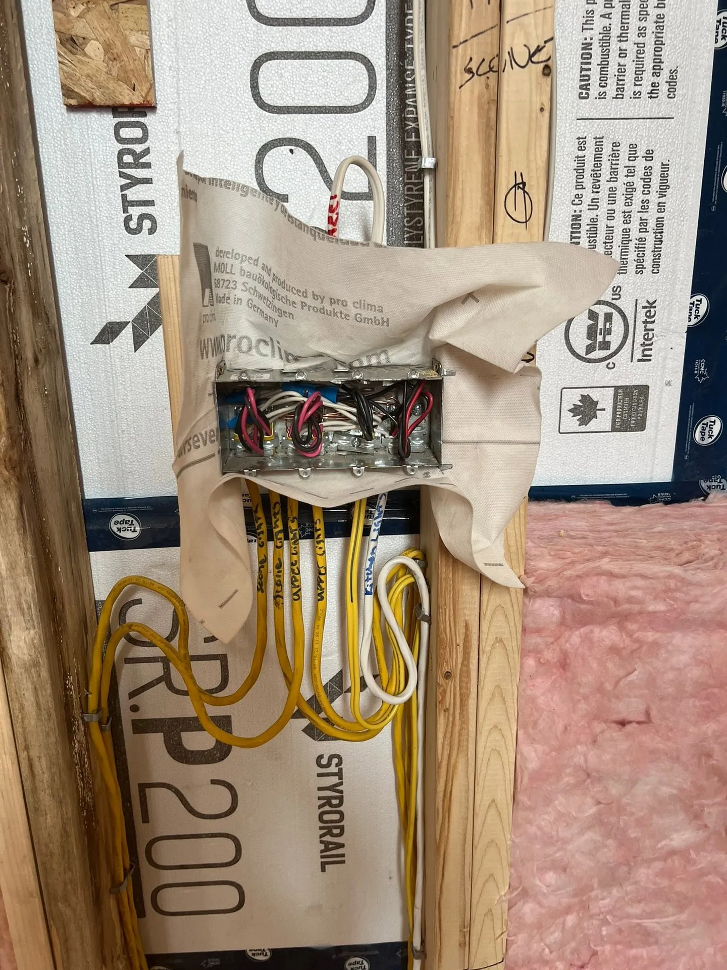 Electrical cables entering a junction box in a framed residential wall.