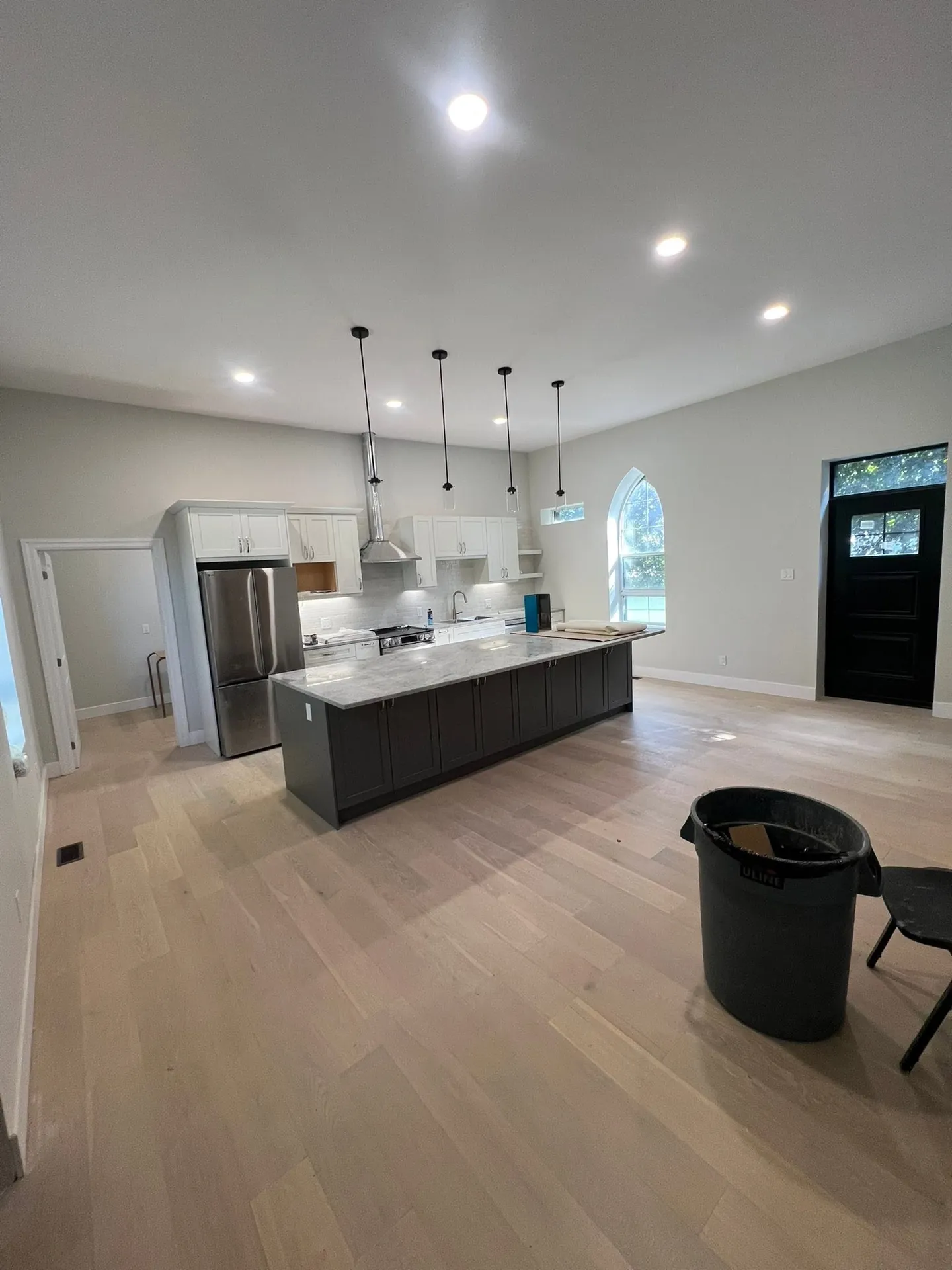 Open-concept kitchen lit by ceiling pot lights and island pendant lights.