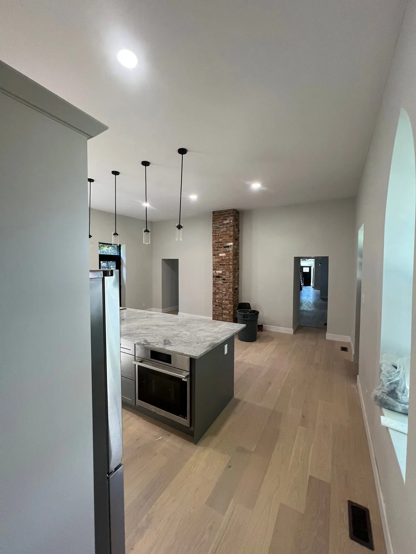 Modern kitchen with ceiling pot lights and pendant lights above the island.