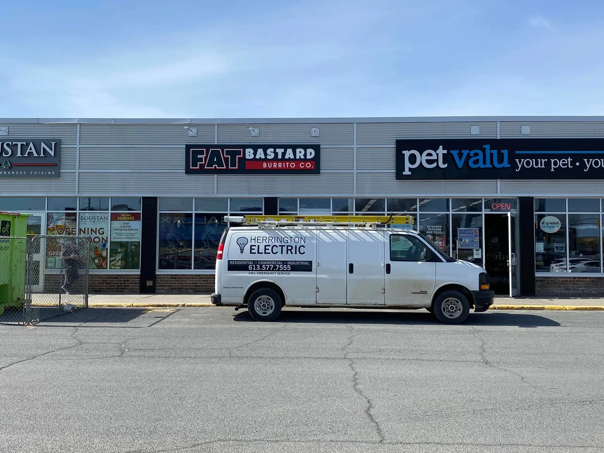 Herrington Electric van outside completed retail storefronts in a commercial plaza.